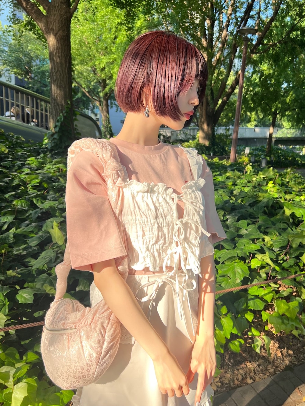 ピンク系のサンダル、ピンク系のボディバッグ/ウエストポーチ、ホワイト系のスカートを着用したレディースの夏コーディネートの5枚目の写真