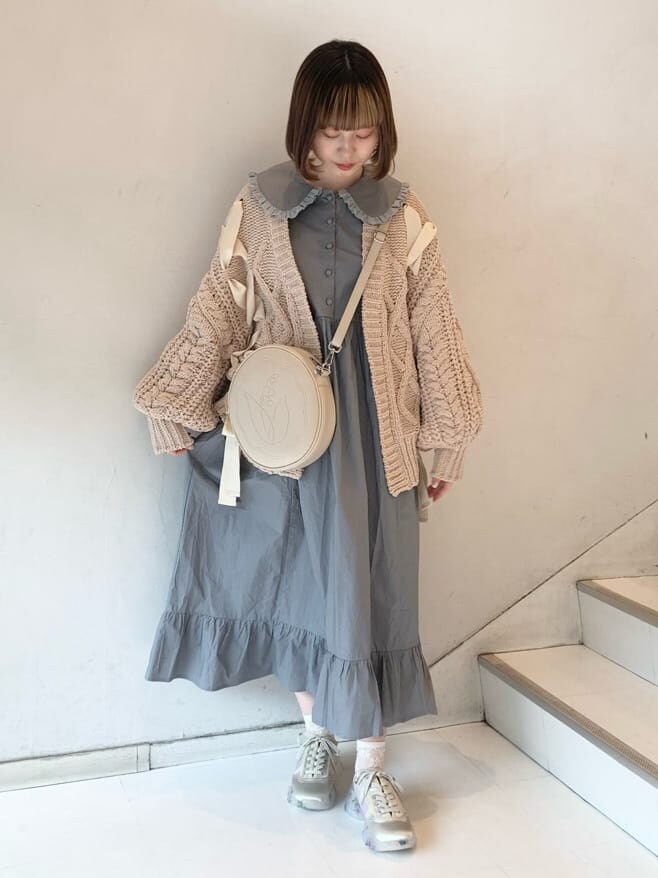 ベージュ系のカーディガン/ボレロ、ホワイト系のスニーカー、ホワイト系のショルダーバッグを着用したレディースの冬コーディネートの6枚目の写真