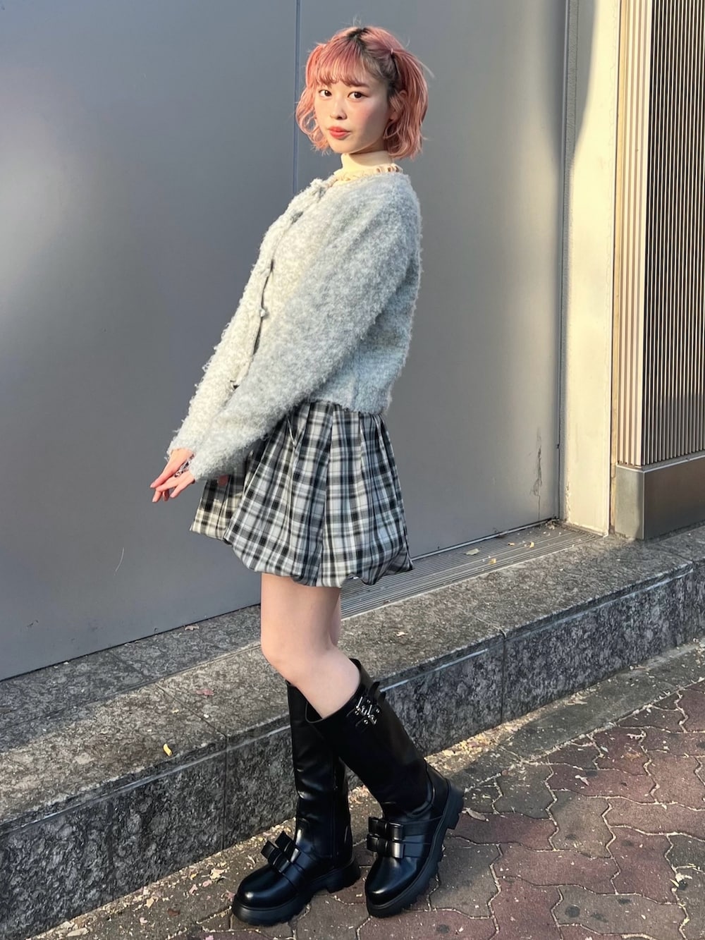 グレー系のカーディガン/ボレロ、ホワイト系のニット/セーター、グレー系のスカートを着用したレディースの冬コーディネートの4枚目の写真