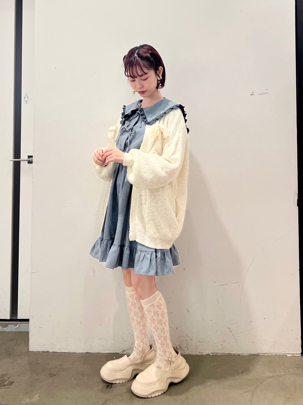 ブルー系のワンピース、ホワイト系のカーディガン/ボレロ、ホワイト系のスニーカーを着用したレディースの秋コーディネートの3枚目の写真