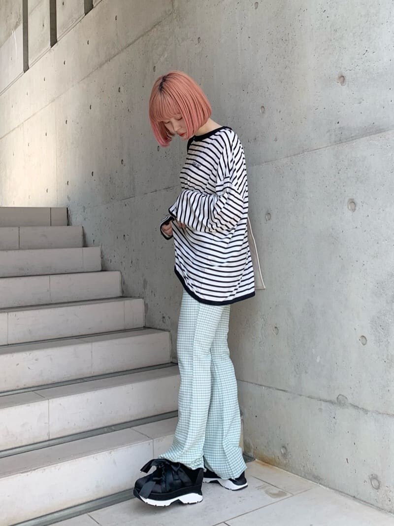 グリーン系のその他パンツ、ブラック系のスニーカー、ホワイト系のトートバッグを着用したレディースの春コーディネートの2枚目の写真