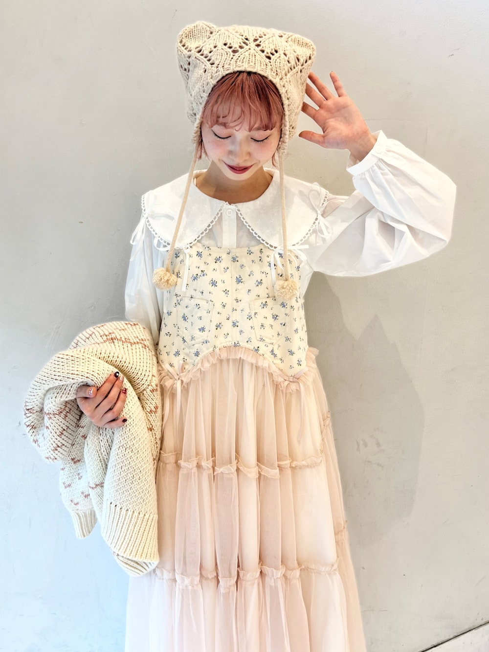 ピンク系のカーディガン/ボレロ、ホワイト系のシャツ/ブラウス、ピンク系のワンピースを着用したレディースの冬コーディネートの10枚目の写真