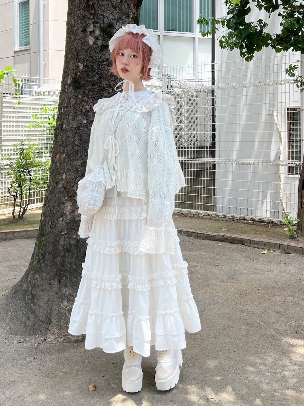 ホワイト系のハンドバッグ、ホワイト系のスカート、ホワイト系のブーツを着用したレディースの夏コーディネートの4枚目の写真