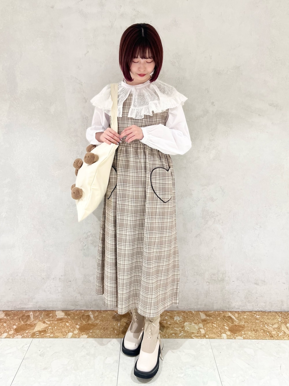 ベージュ系のワンピース、ホワイト系のシャツ/ブラウス、ホワイト系のカーディガン/ボレロを着用したレディースの秋コーディネートの4枚目の写真