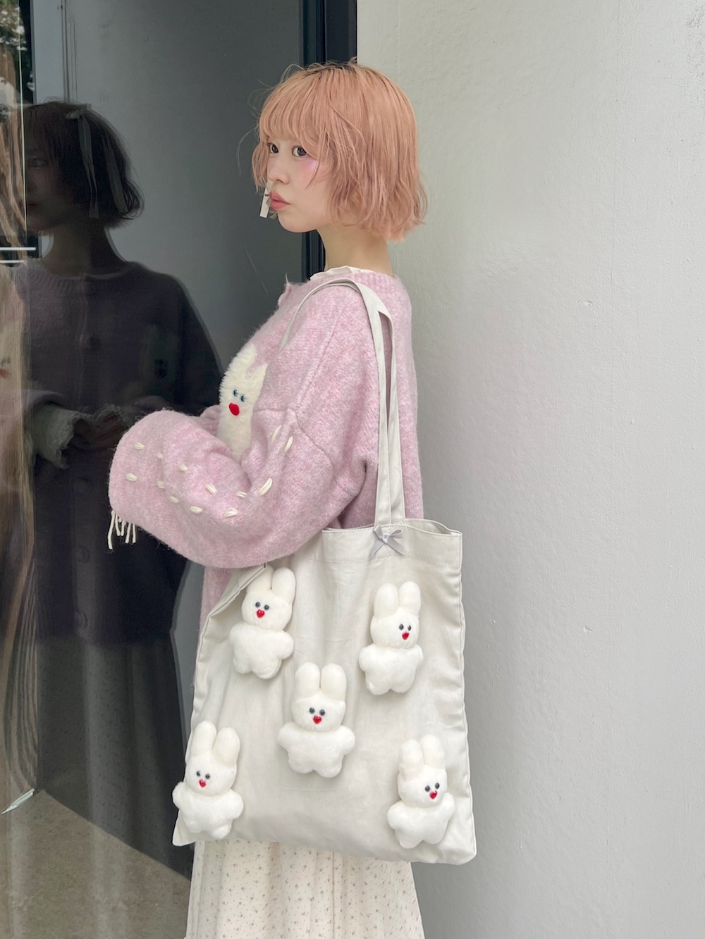 ホワイト系のブーツ、ピンク系のカーディガン/ボレロ、ホワイト系のトートバッグを着用したレディースの秋コーディネートの5枚目の写真