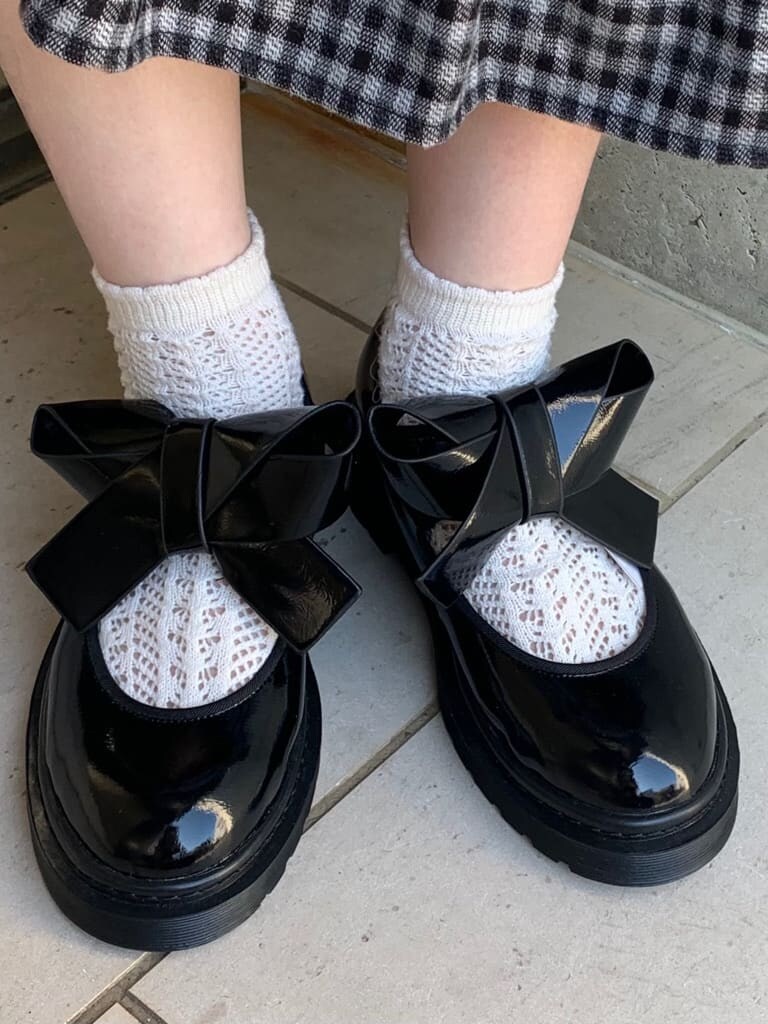 ブラック系のパンプス、ホワイト系のショルダーバッグ、ブラック系のスカートを着用したレディースの冬コーディネートの7枚目の写真