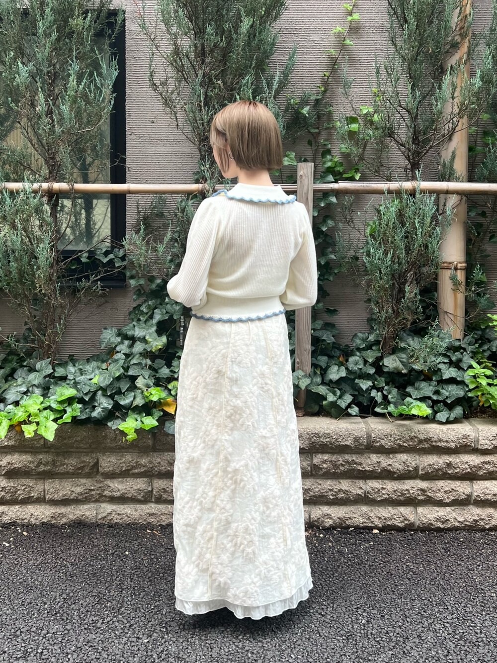 ホワイト系のニット/セーター、ホワイト系のワンピース、ブルー系のパンプスを着用したレディースの冬コーディネートの5枚目の写真