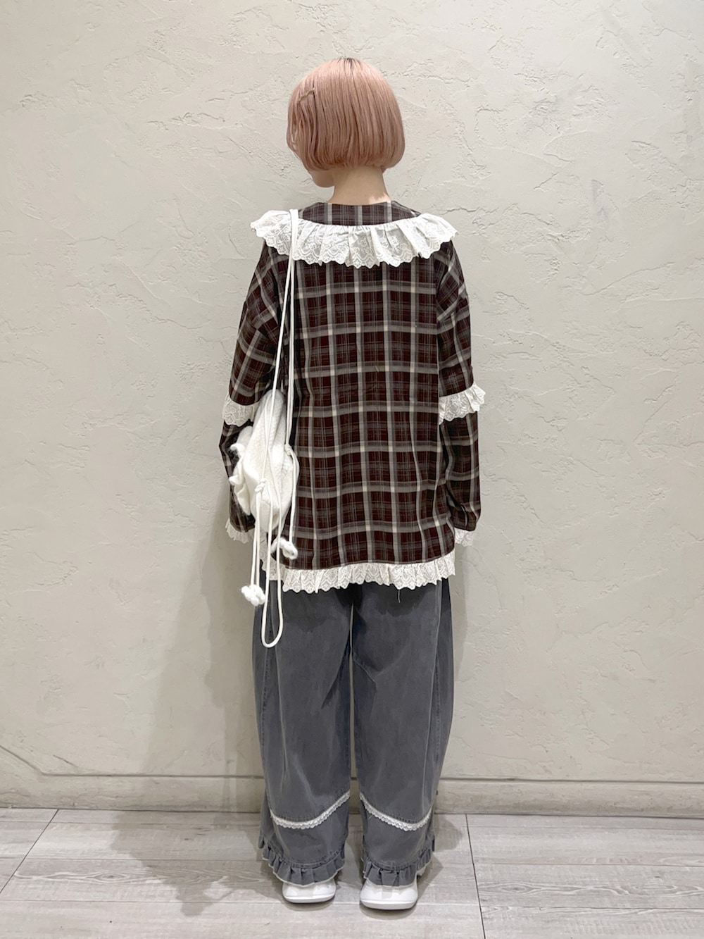 ブラウン系のシャツ/ブラウス、グレー系のデニムパンツ、ホワイト系のスニーカーを着用したレディースの秋コーディネートの3枚目の写真
