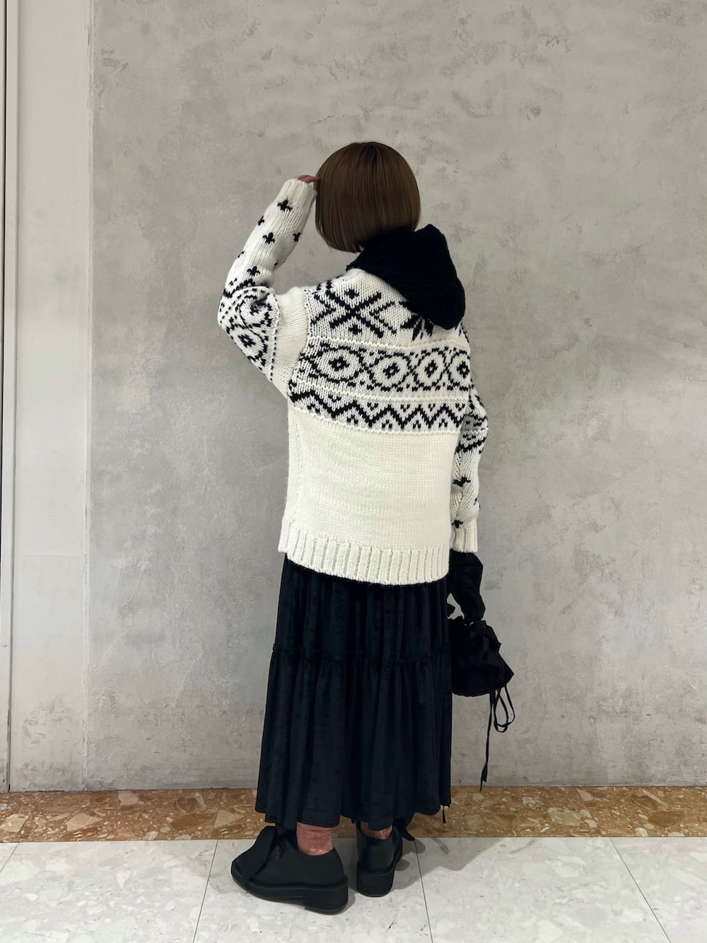 ホワイト系のニット/セーター、ブラック系のショルダーバッグ、ブラック系のモカシン/デッキシューズを着用したレディースの冬コーディネートの6枚目の写真