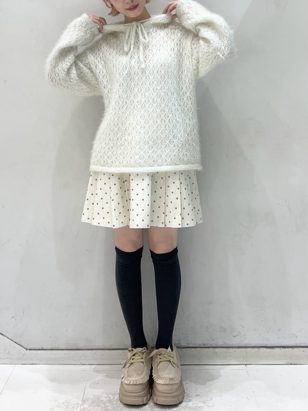 ホワイト系のニット/セーター、ホワイト系のスカート、ベージュ系のローファーを着用したレディースの冬コーディネートの4枚目の写真