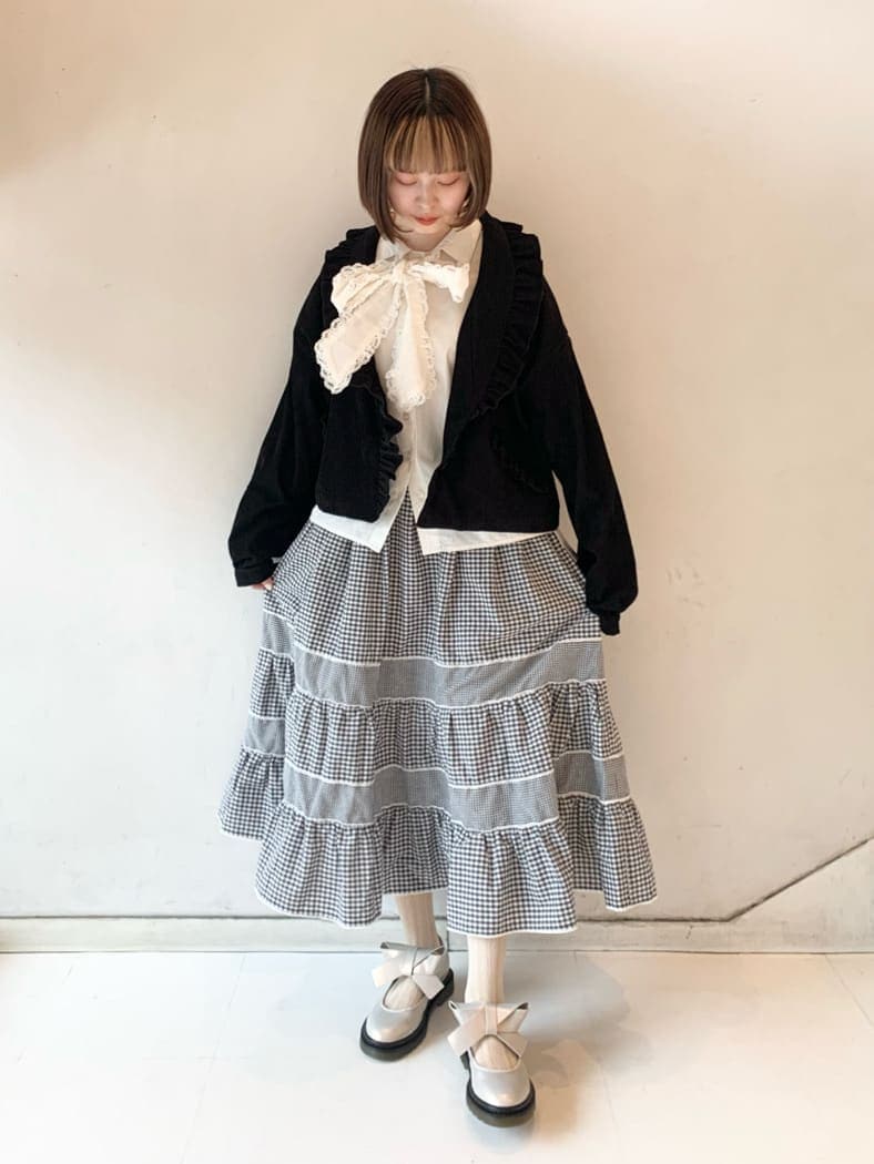 ホワイト系のパンプス、ブラック系のその他アウター、ホワイト系のシャツ/ブラウスを着用したレディースの冬コーディネートの2枚目の写真