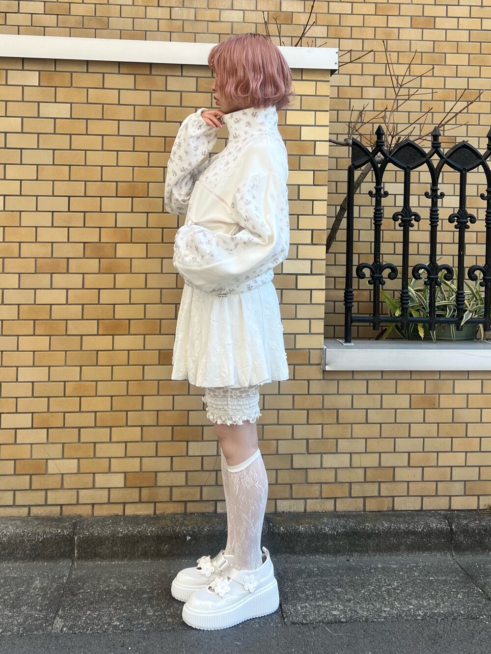 ピンク系のジャージ、ホワイト系のスカート、ホワイト系のスニーカーを着用したレディースの冬コーディネートの3枚目の写真