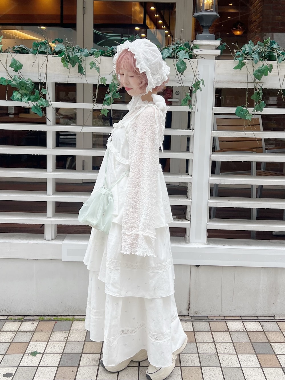 ホワイト系のTシャツ/カットソー、グリーン系のハンドバッグ、ホワイト系のワンピースを着用したレディースの冬コーディネートの3枚目の写真