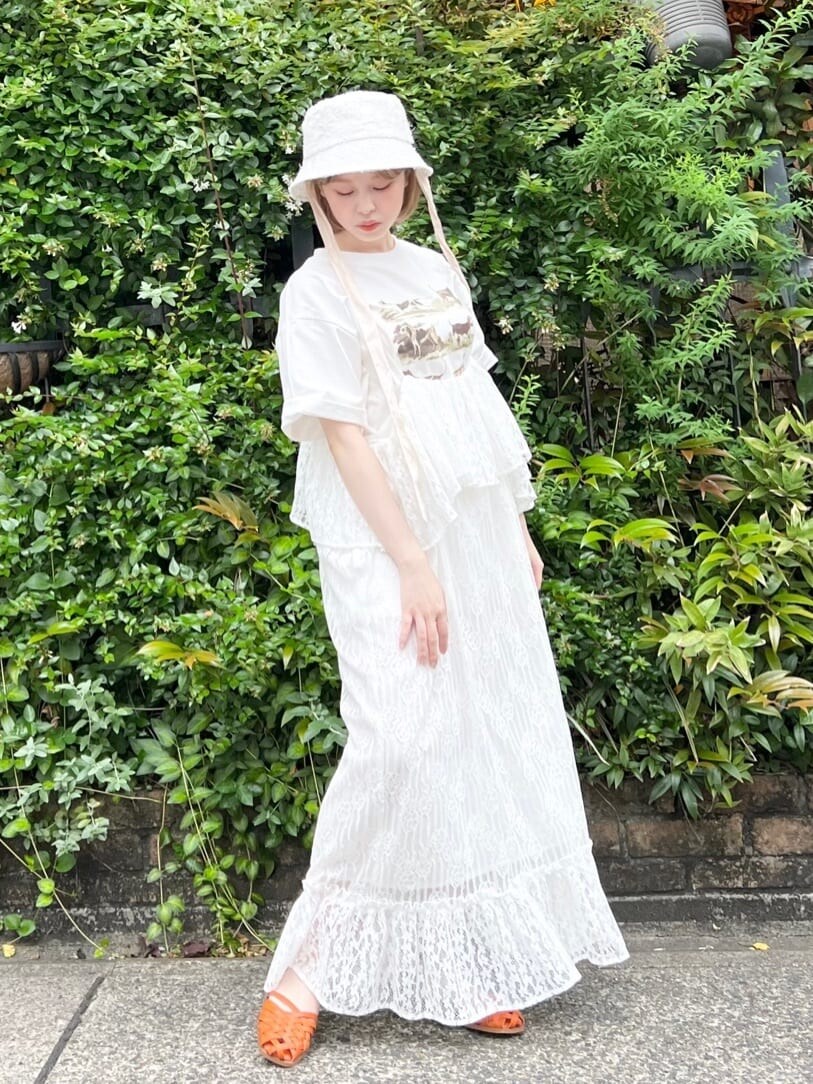 オレンジ系のパンプス、ホワイト系のスカート、ベージュ系のTシャツ/カットソーを着用したレディースの夏コーディネートの3枚目の写真