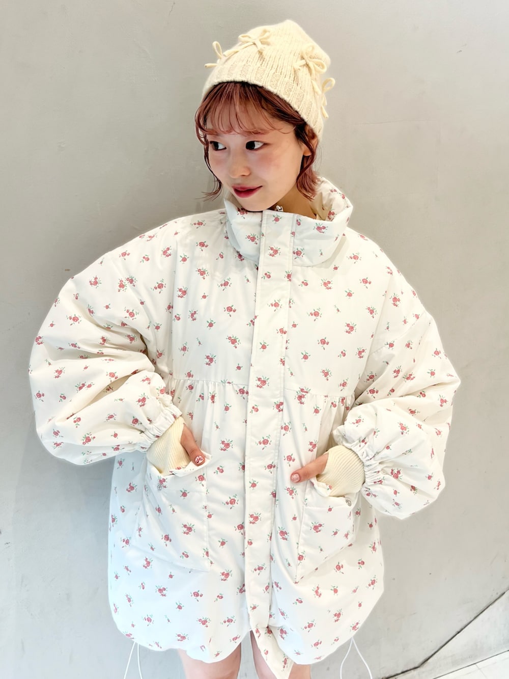 ピンク系のブルゾン、ベージュ系のスウェットパンツ、ホワイト系のニット/セーターを着用したレディースの冬コーディネートの9枚目の写真