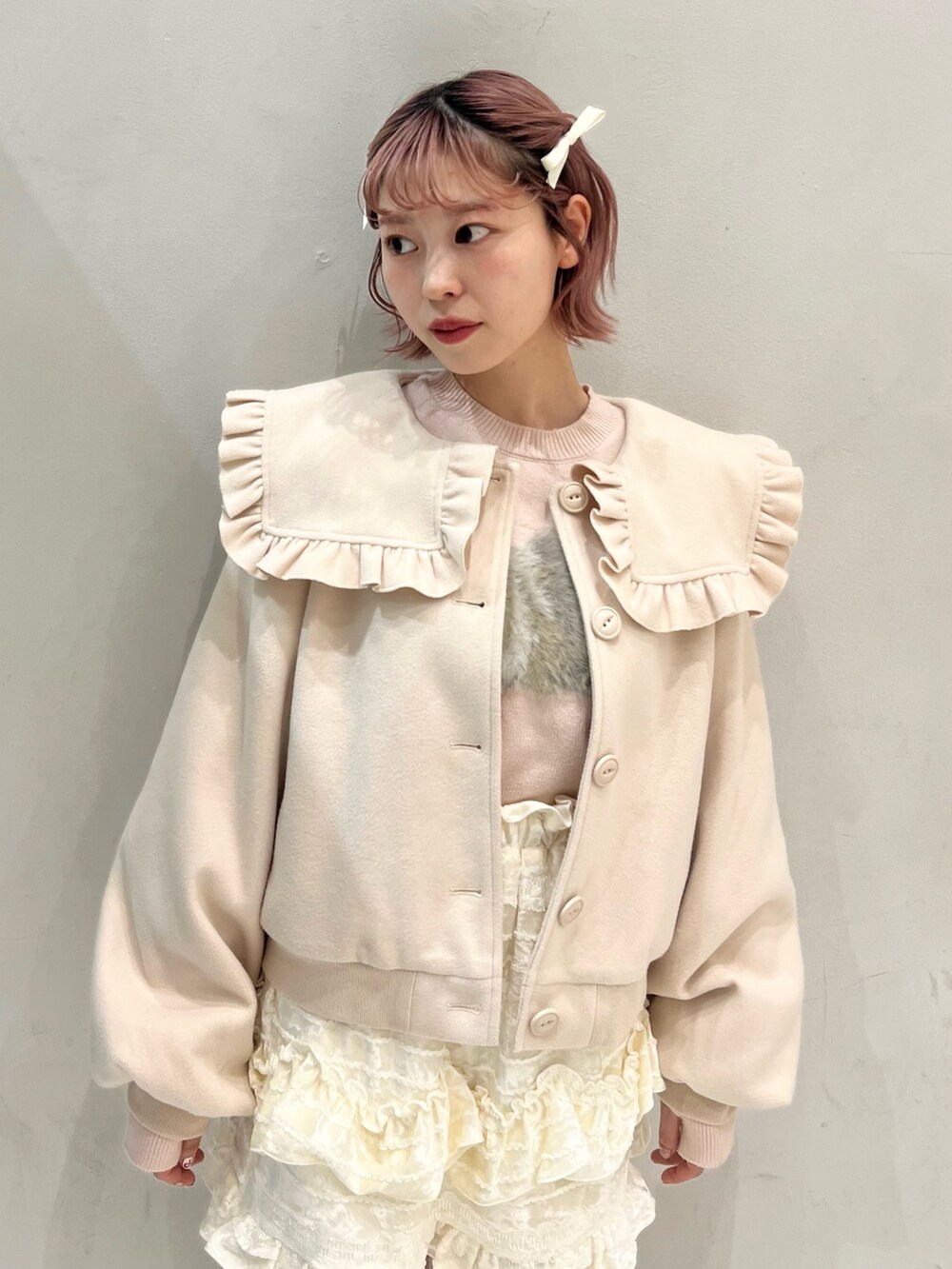 ホワイト系のブルゾン、ピンク系のショルダーバッグ、ホワイト系のスカートを着用したレディースの冬コーディネートの4枚目の写真