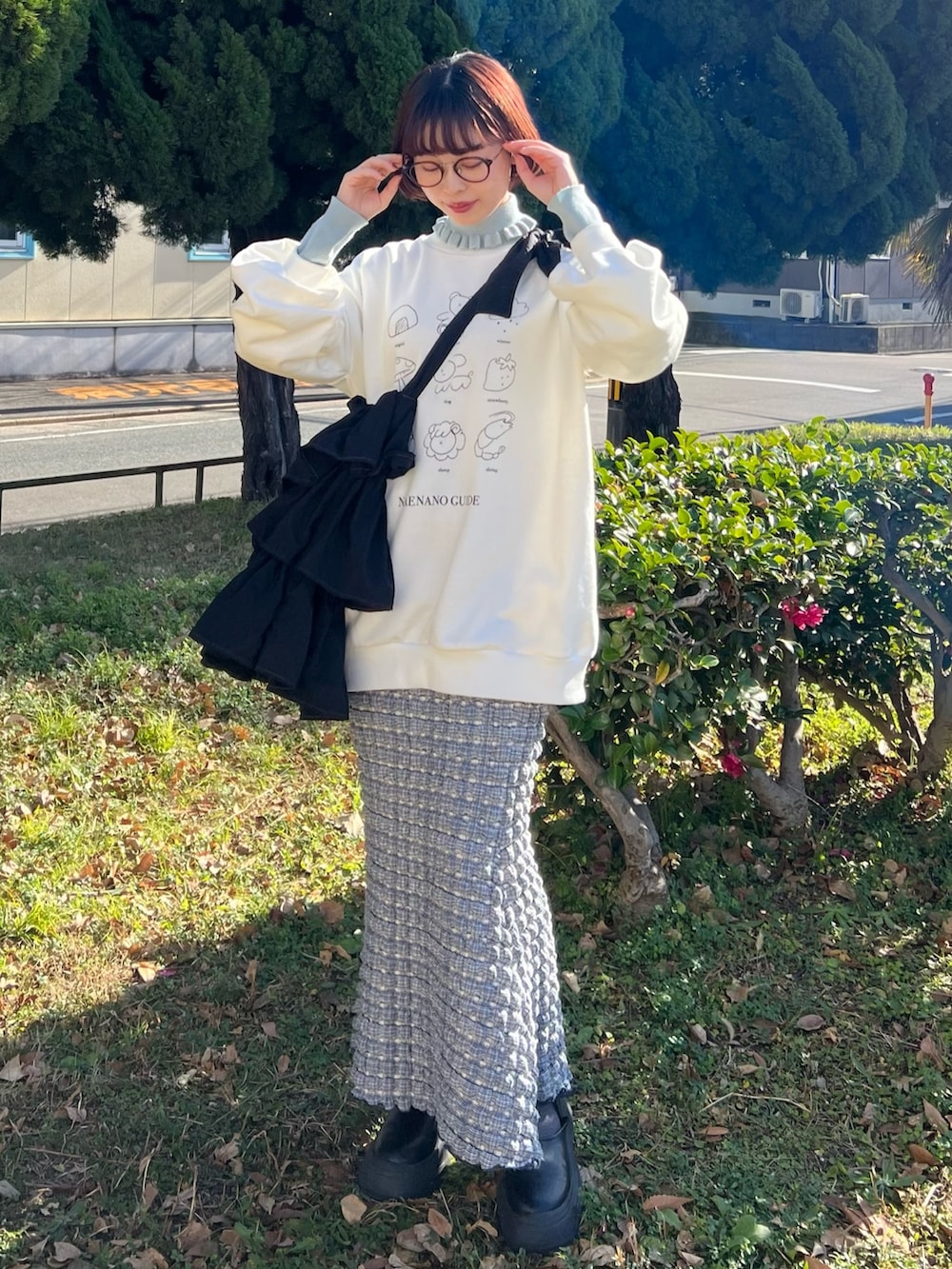 ブルー系のニット/セーター、ホワイト系のスウェット、ブラック系のトートバッグを着用したレディースの冬コーディネートの6枚目の写真