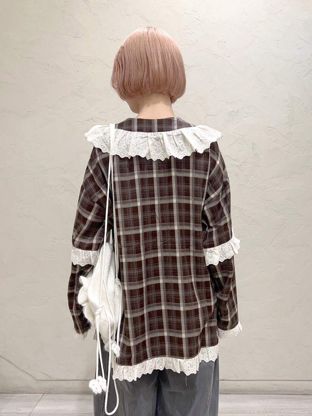 ブラウン系のシャツ/ブラウス、グレー系のデニムパンツ、ホワイト系のスニーカーを着用したレディースの秋コーディネートの5枚目の写真