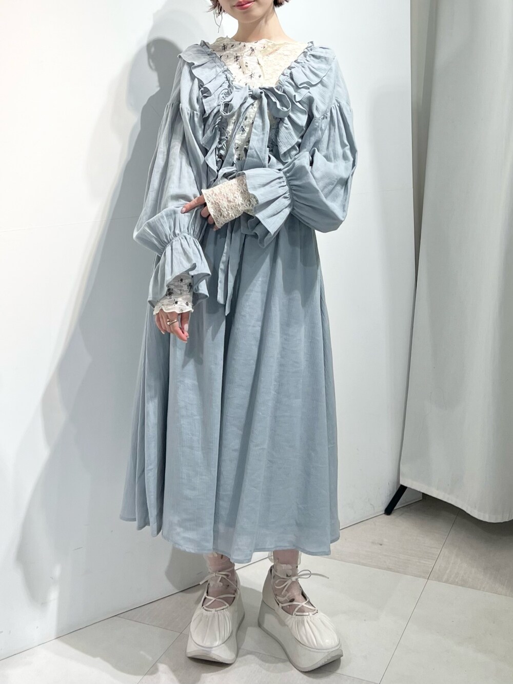 ホワイト系のTシャツ/カットソー、ホワイト系のバレエシューズ、グリーン系のワンピースを着用したレディースの冬コーディネートの3枚目の写真