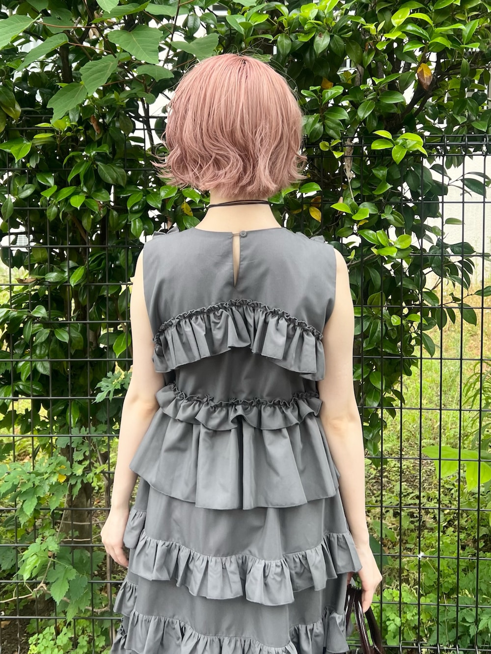 グレー系のワンピース、ブラウン系のハンドバッグ、ブラック系のブーツを着用したレディースの夏コーディネートの7枚目の写真