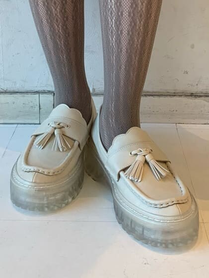 ホワイト系のローファー、ベージュ系のワンピース、パープル系のカーディガン/ボレロを着用したレディースの冬コーディネートの9枚目の写真