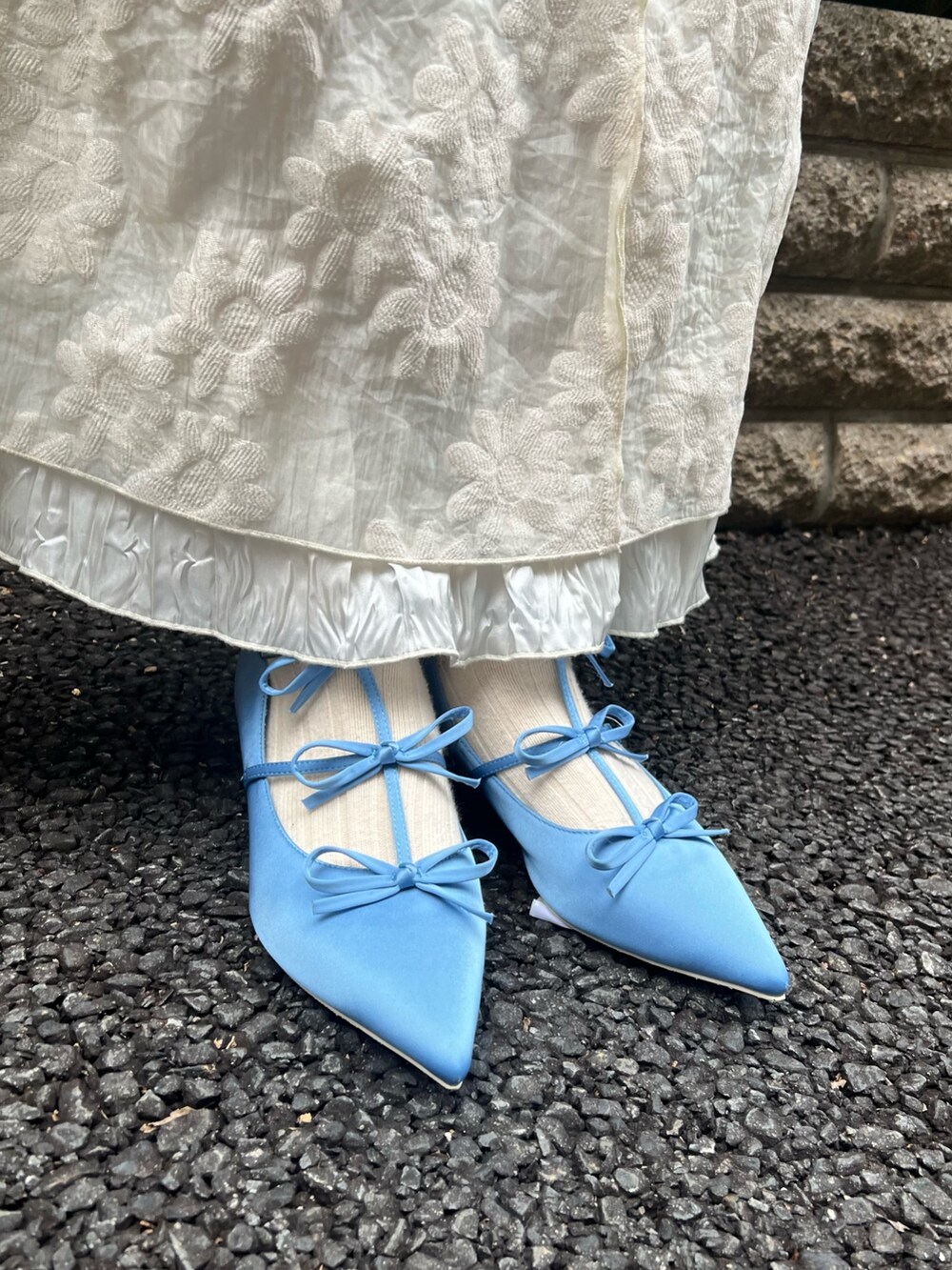 ホワイト系のニット/セーター、ホワイト系のワンピース、ブルー系のパンプスを着用したレディースの冬コーディネートの9枚目の写真