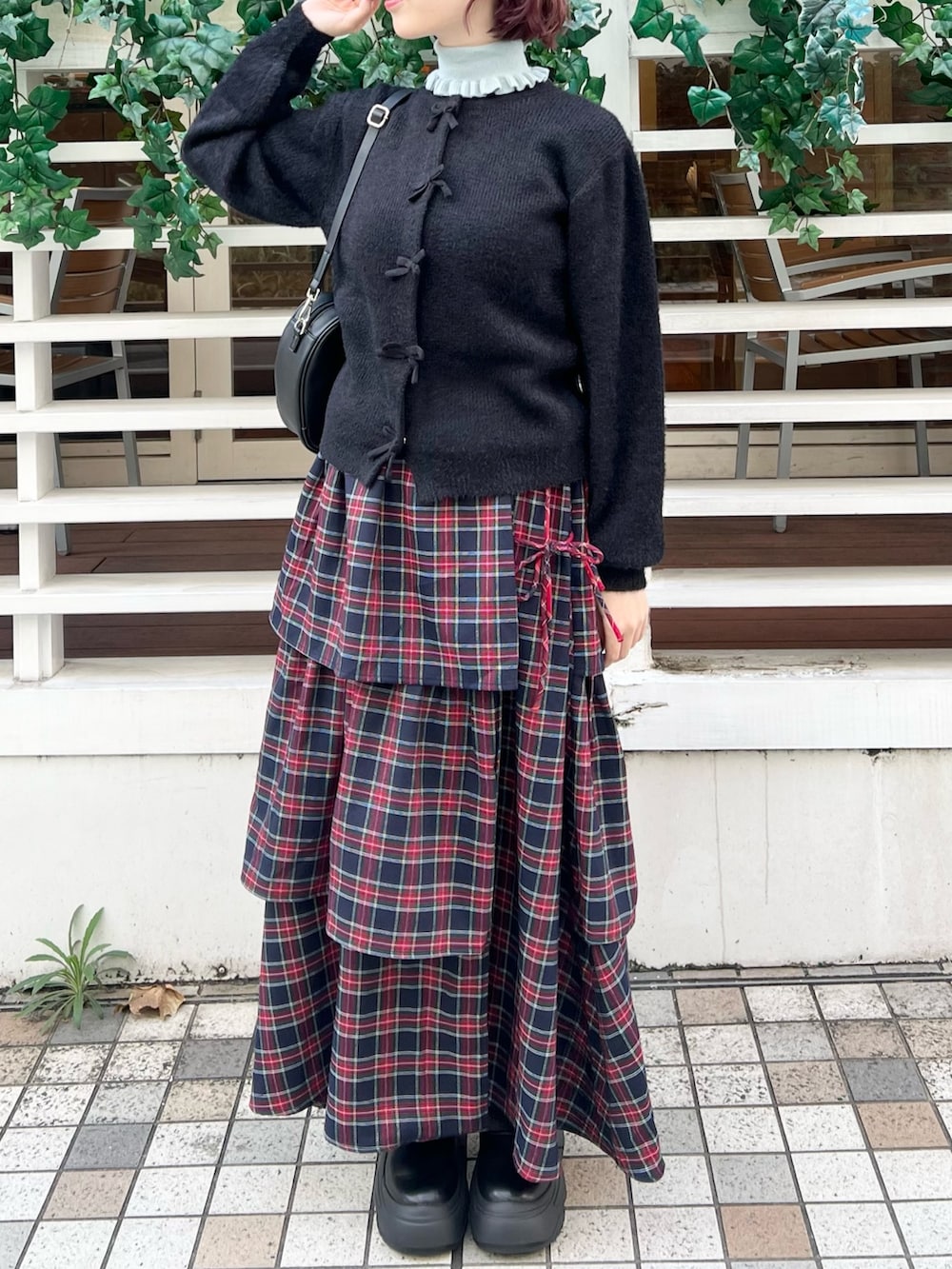 ブルー系のニット/セーター、ブルー系のスカート、ブラック系のスニーカーを着用したレディースの秋コーディネートの2枚目の写真