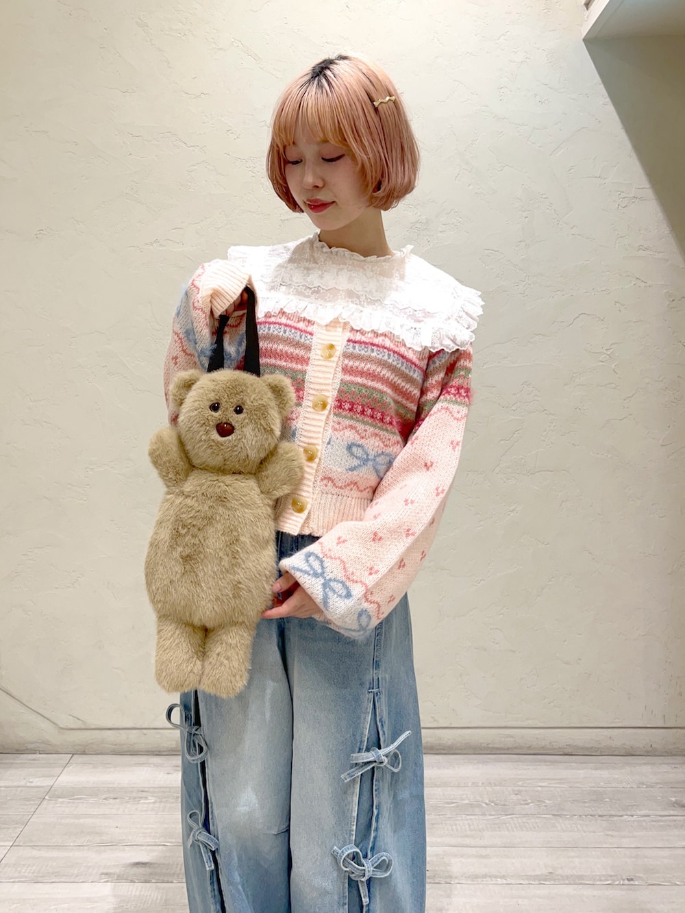 ピンク系のカーディガン/ボレロ、ホワイト系のシャツ/ブラウス、ベージュ系のハンドバッグを着用したレディースの秋コーディネートの6枚目の写真