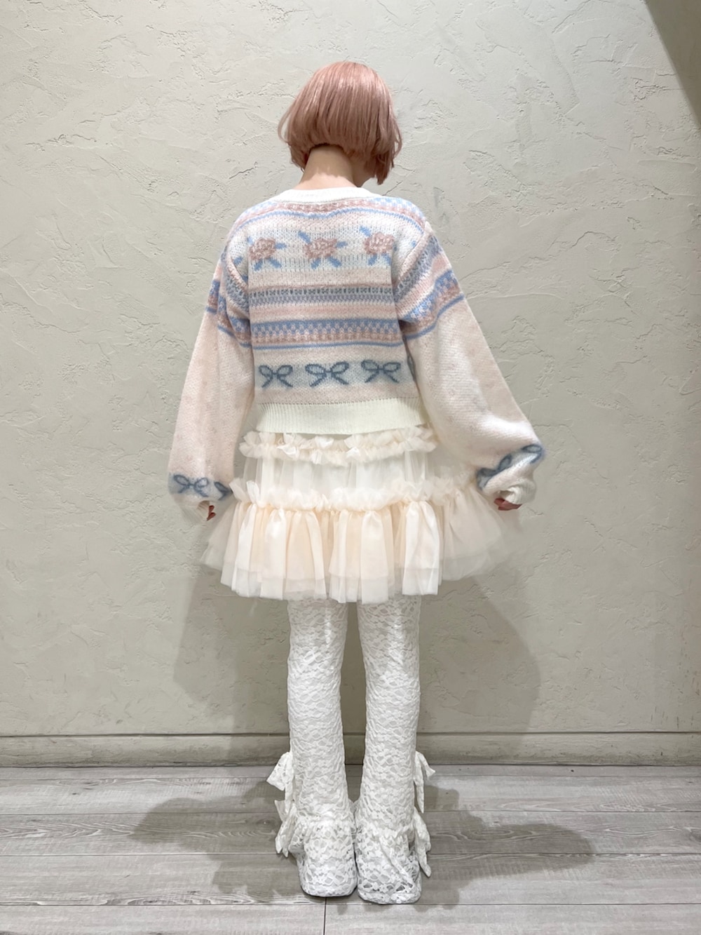 ホワイト系のカーディガン/ボレロ、ピンク系のスカート、ホワイト系のハンドバッグを着用したレディースの秋コーディネートの5枚目の写真