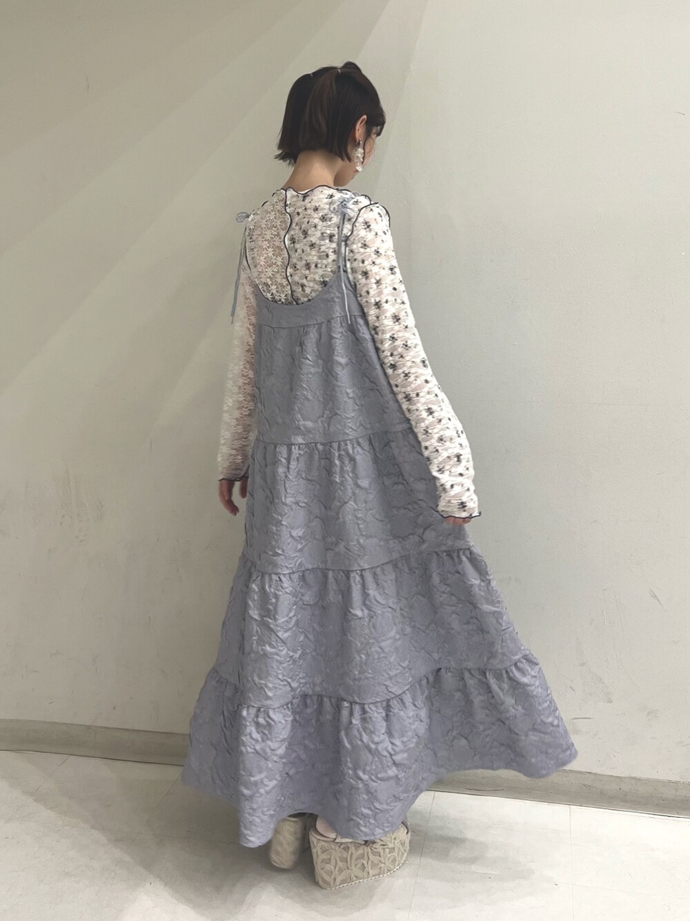 パープル系のワンピース、ホワイト系のTシャツ/カットソー、ホワイト系のサンダルを着用したレディースの夏コーディネートの4枚目の写真