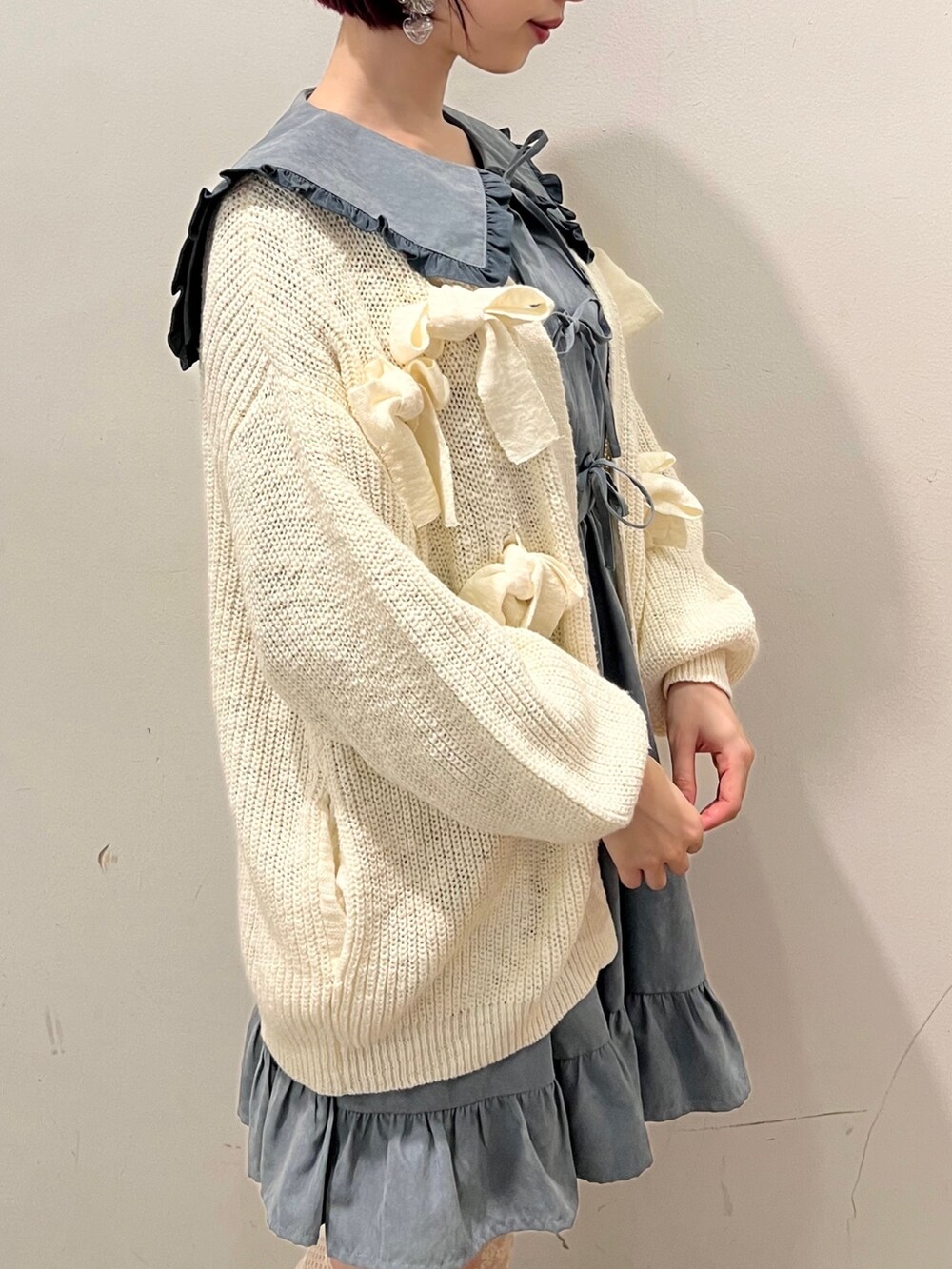 ブルー系のワンピース、ホワイト系のカーディガン/ボレロ、ホワイト系のスニーカーを着用したレディースの秋コーディネートの7枚目の写真