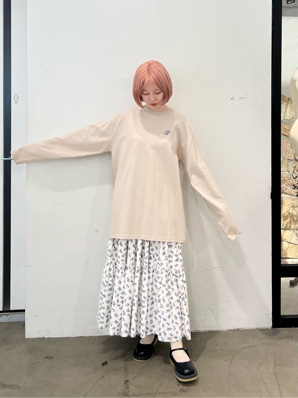 ホワイト系のスカート、ブラック系のパンプス、ベージュ系のTシャツ/カットソーを着用したレディースの夏コーディネートの3枚目の写真