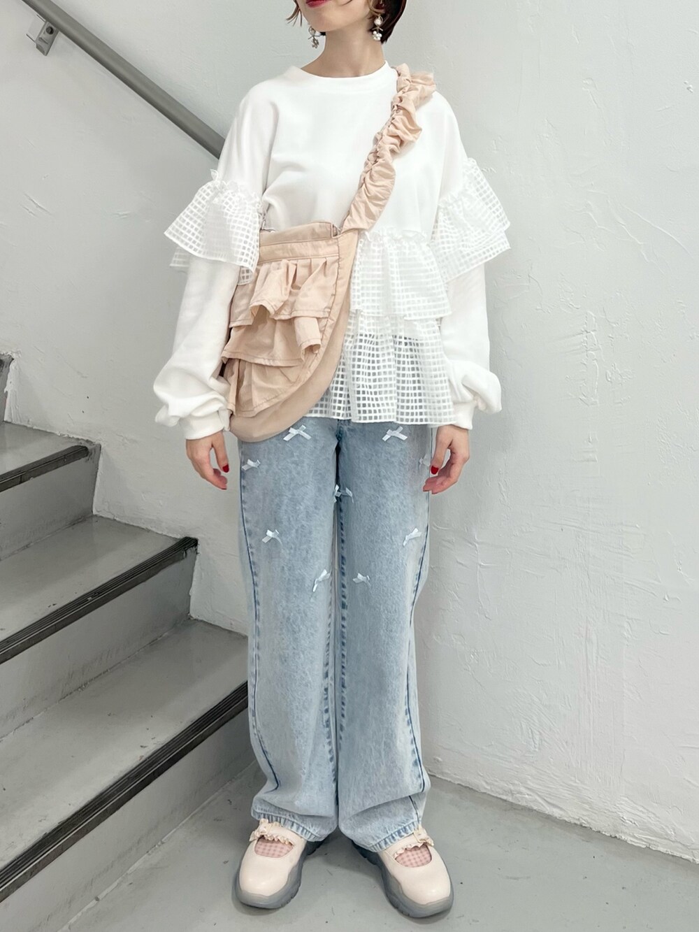 ホワイト系のスウェット、ブルー系のデニムパンツ、ホワイト系のスニーカーを着用したレディースの春コーディネートの4枚目の写真