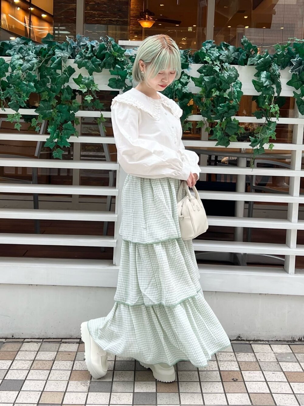 ホワイト系のシャツ/ブラウス、グリーン系のスカート、ホワイト系のボストンバッグを着用したレディースの秋コーディネートの4枚目の写真