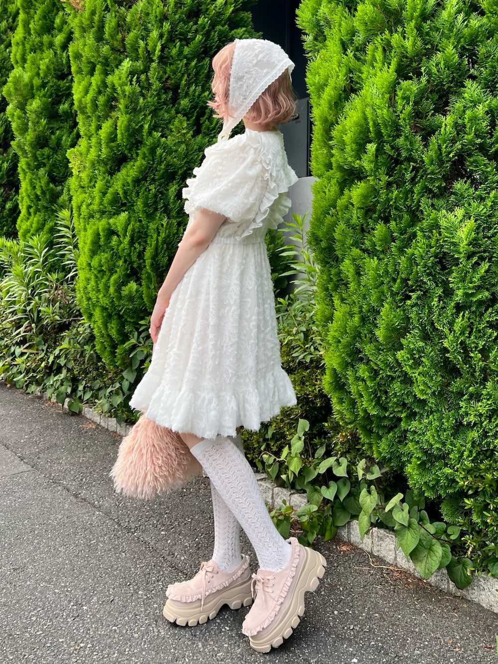 ホワイト系のワンピース、ピンク系のボストンバッグ、ピンク系のローファーを着用したレディースの夏コーディネートの5枚目の写真
