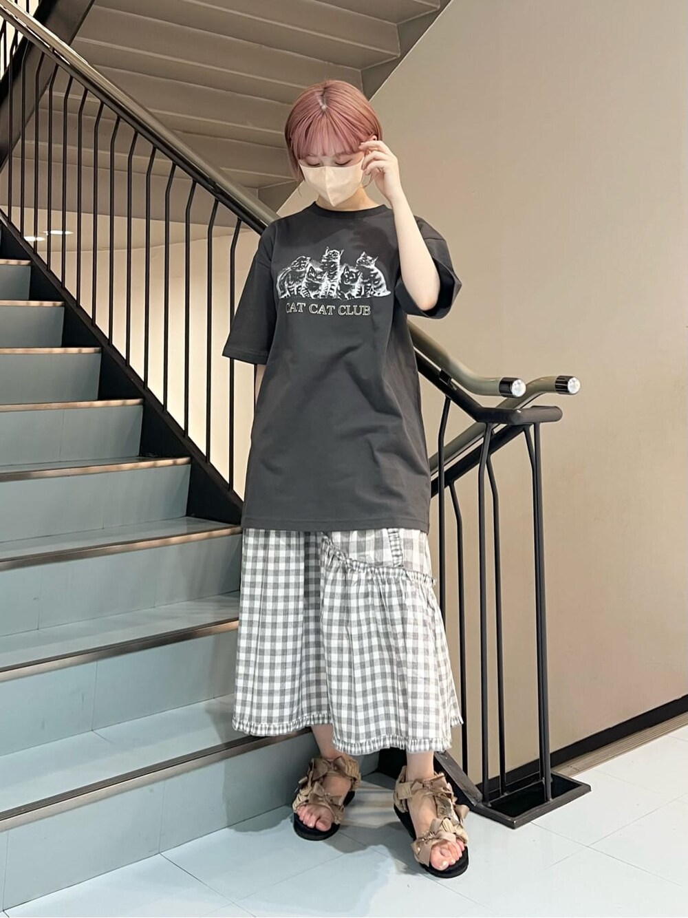 グレー系のスカート、ベージュ系のサンダル、グレー系のTシャツ/カットソーを着用したレディースの夏コーディネートの2枚目の写真