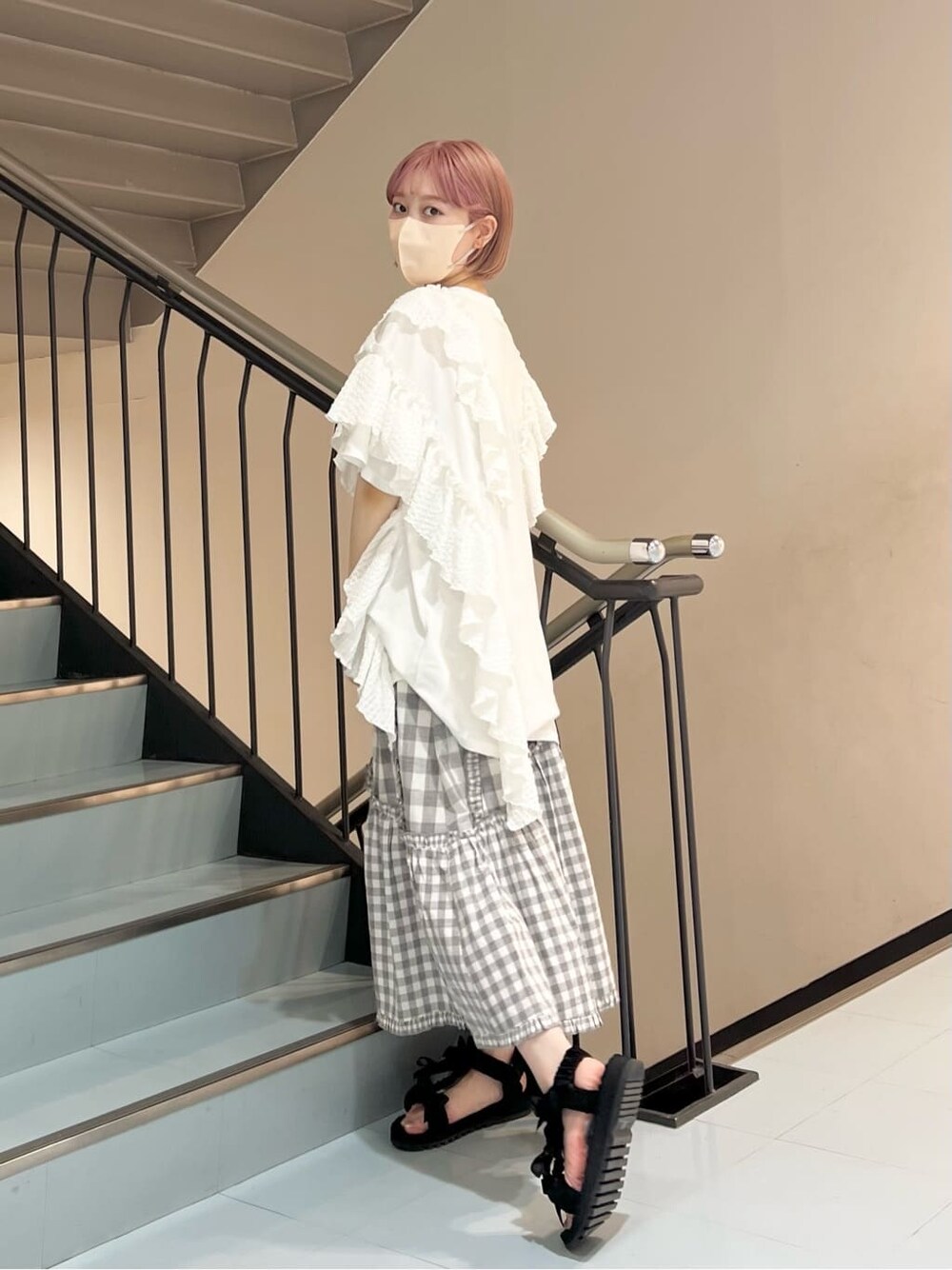 ホワイト系のチュニック、グレー系のスカート、ブラック系のサンダルを着用したレディースの夏コーディネートの4枚目の写真