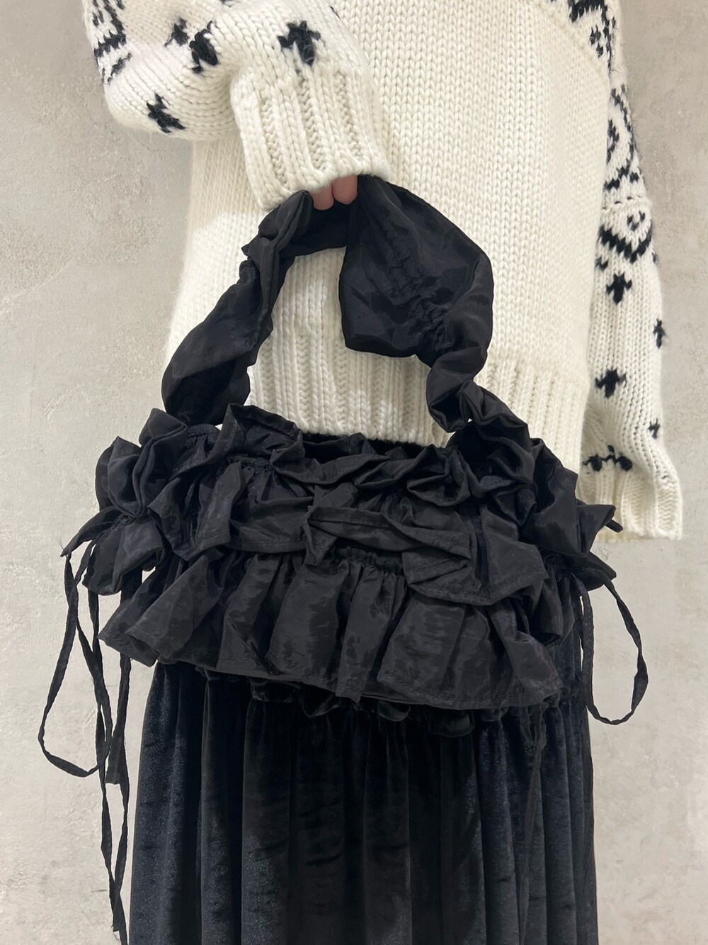 ホワイト系のニット/セーター、ブラック系のショルダーバッグ、ブラック系のモカシン/デッキシューズを着用したレディースの冬コーディネートの10枚目の写真