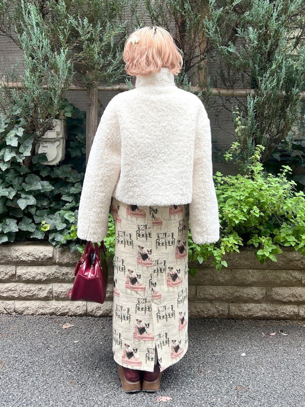 ホワイト系のブルゾン、ベージュ系のジャンパースカート、レッド系のハンドバッグを着用したレディースの秋コーディネートの3枚目の写真
