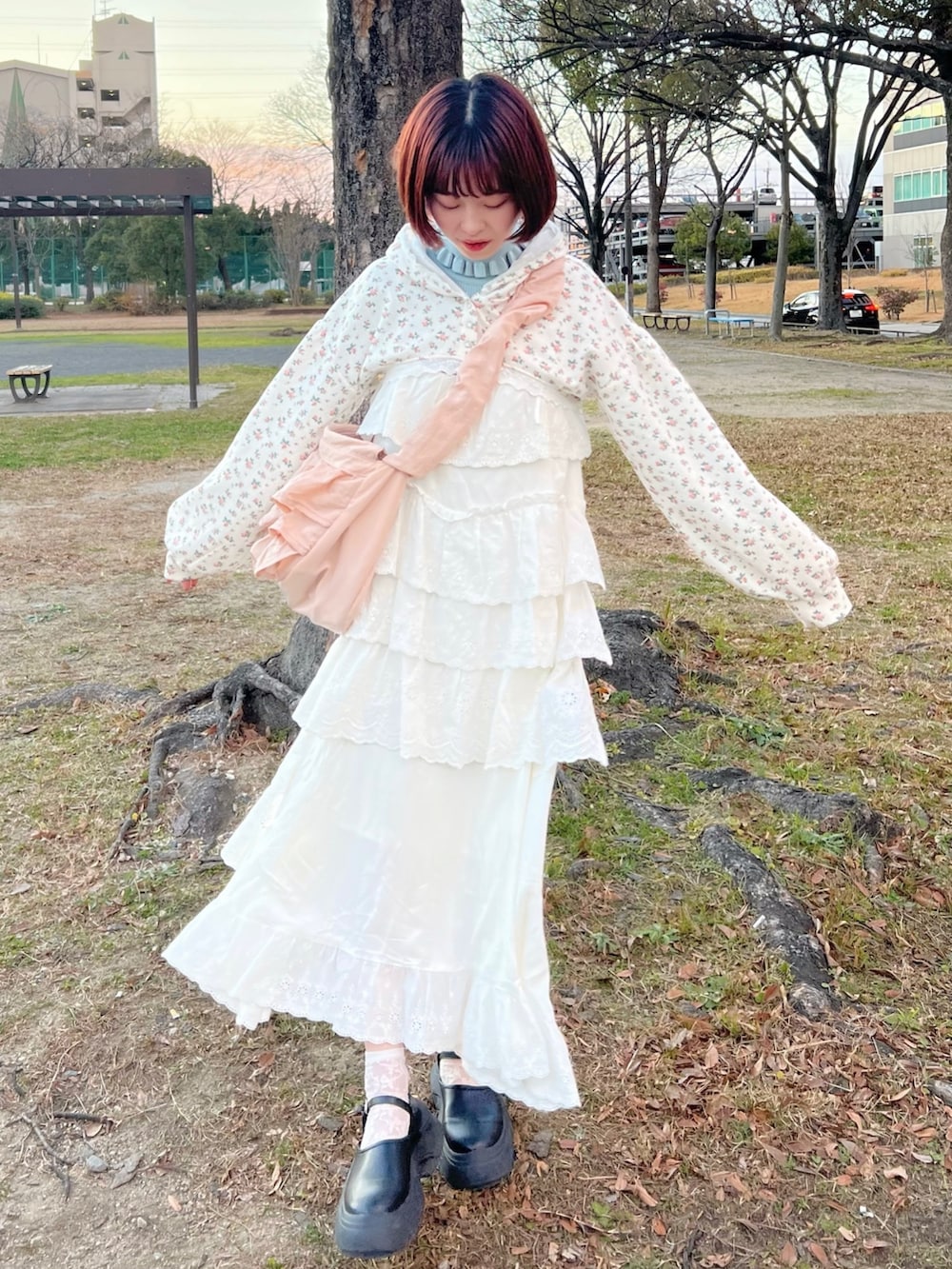 ホワイト系のワンピース、その他のカーディガン/ボレロ、ピンク系のショルダーバッグを着用したレディースの冬コーディネートの3枚目の写真