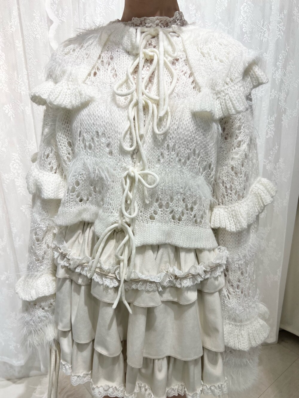 ホワイト系のボストンバッグ、ブラウン系のブーツ、ホワイト系のスカートを着用したレディースの夏コーディネートの7枚目の写真