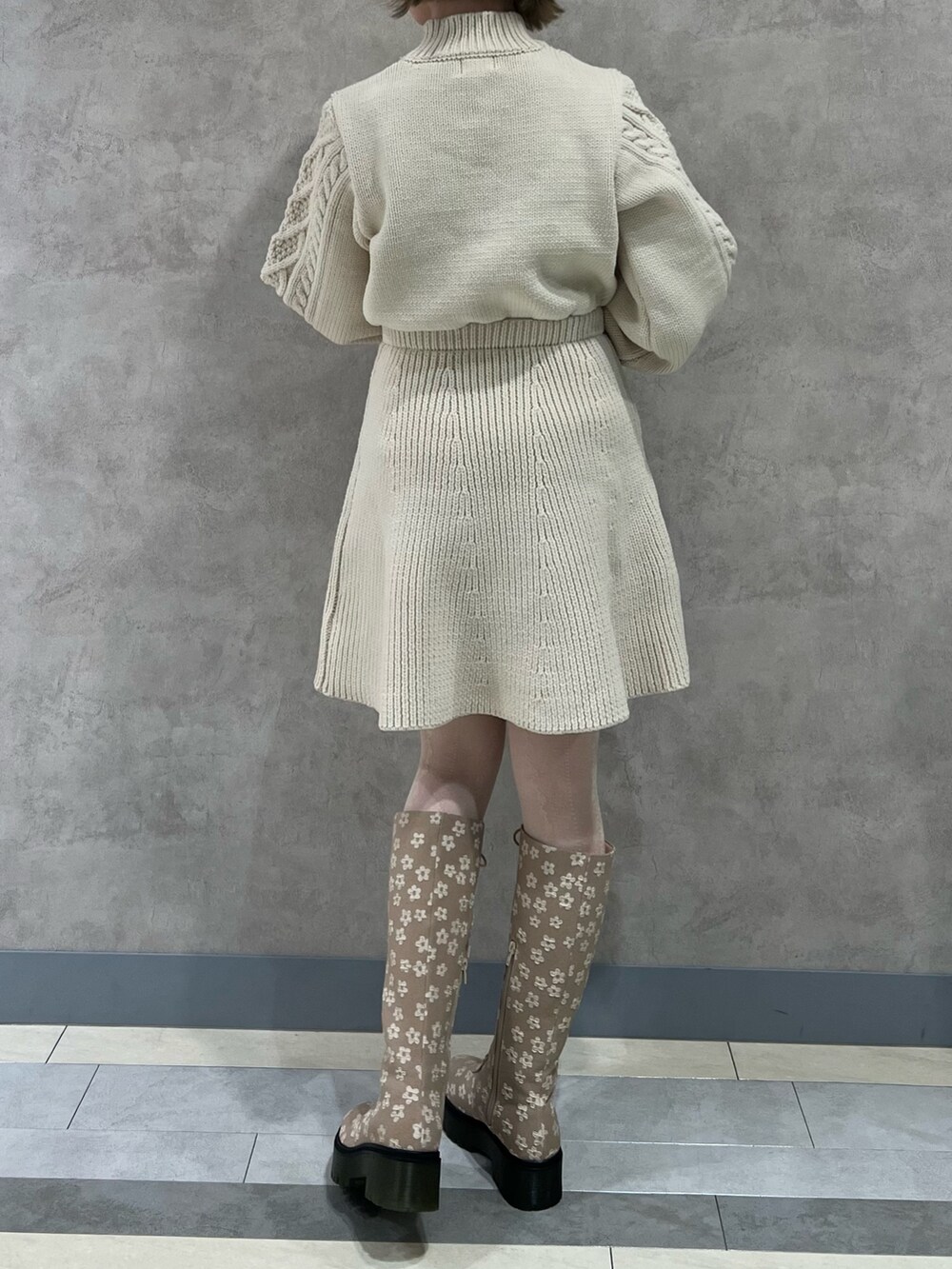 ホワイト系のワンピース、ベージュ系のブーツ、ホワイト系のショルダーバッグを着用したレディースの冬コーディネートの5枚目の写真