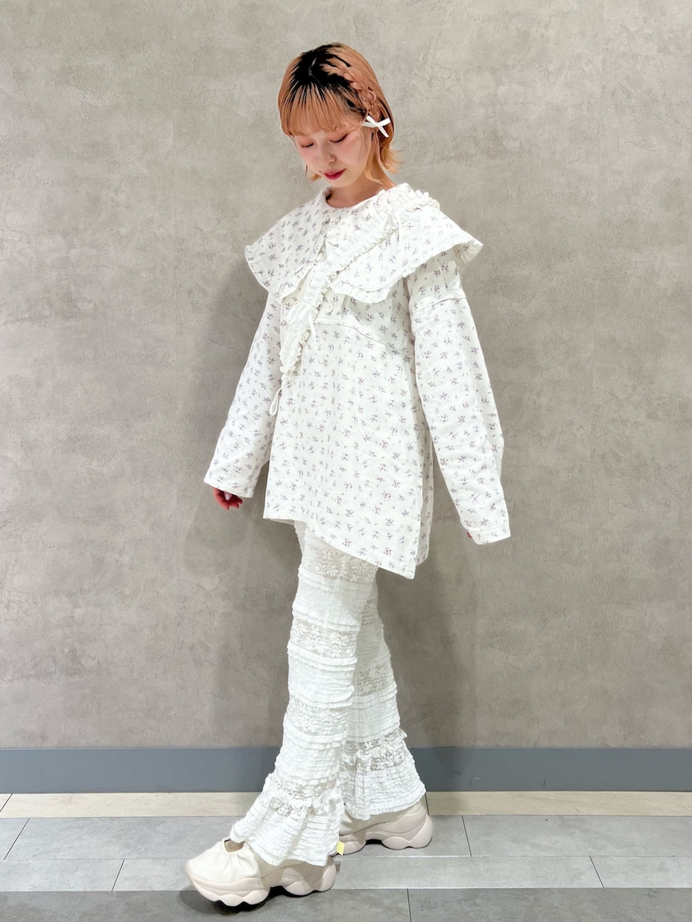 ホワイト系のデニムジャケット、ホワイト系のスラックス、ホワイト系のスニーカーを着用したレディースの秋コーディネートの3枚目の写真