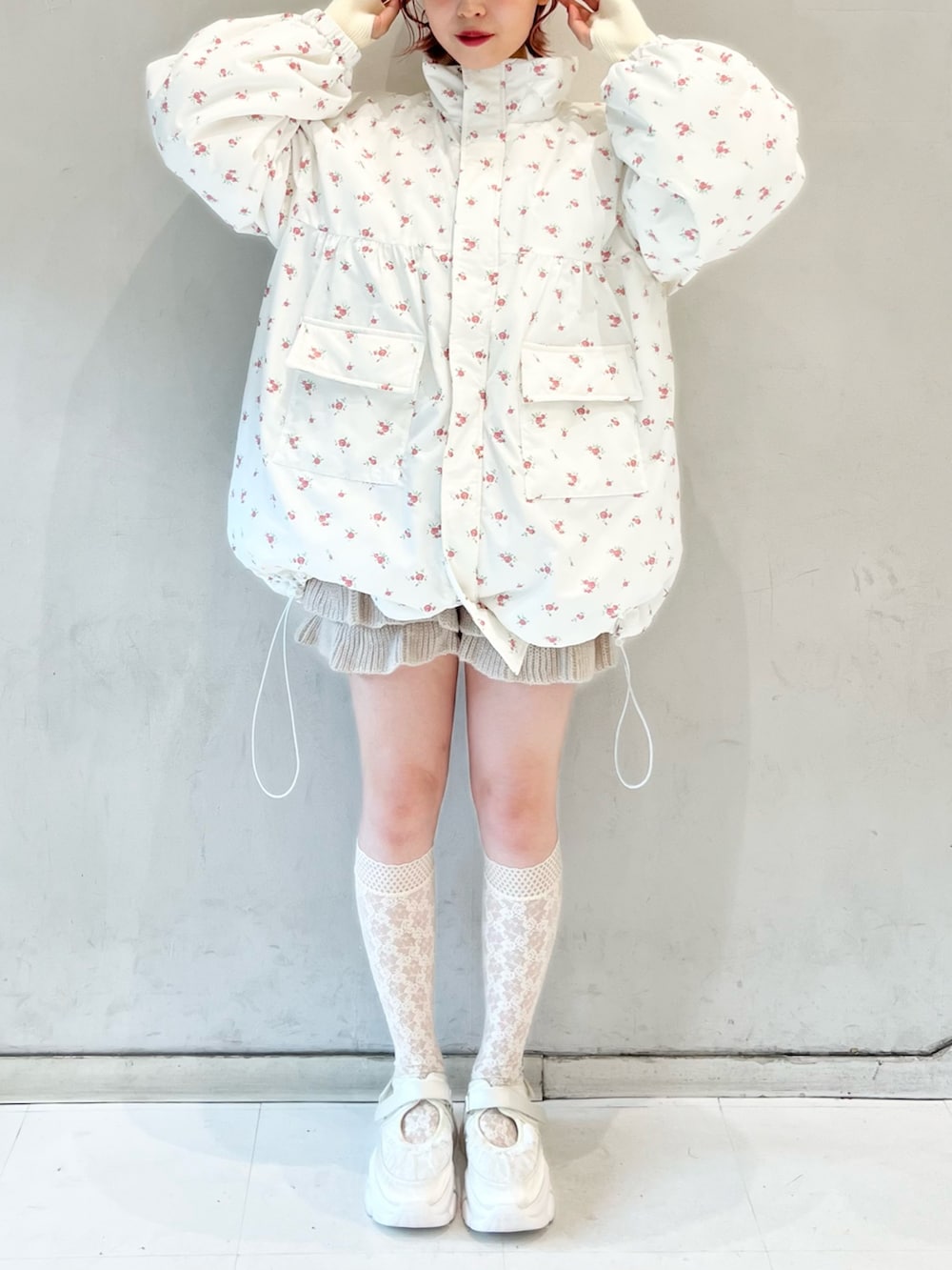 ピンク系のブルゾン、ベージュ系のスウェットパンツ、ホワイト系のニット/セーターを着用したレディースの冬コーディネートの2枚目の写真