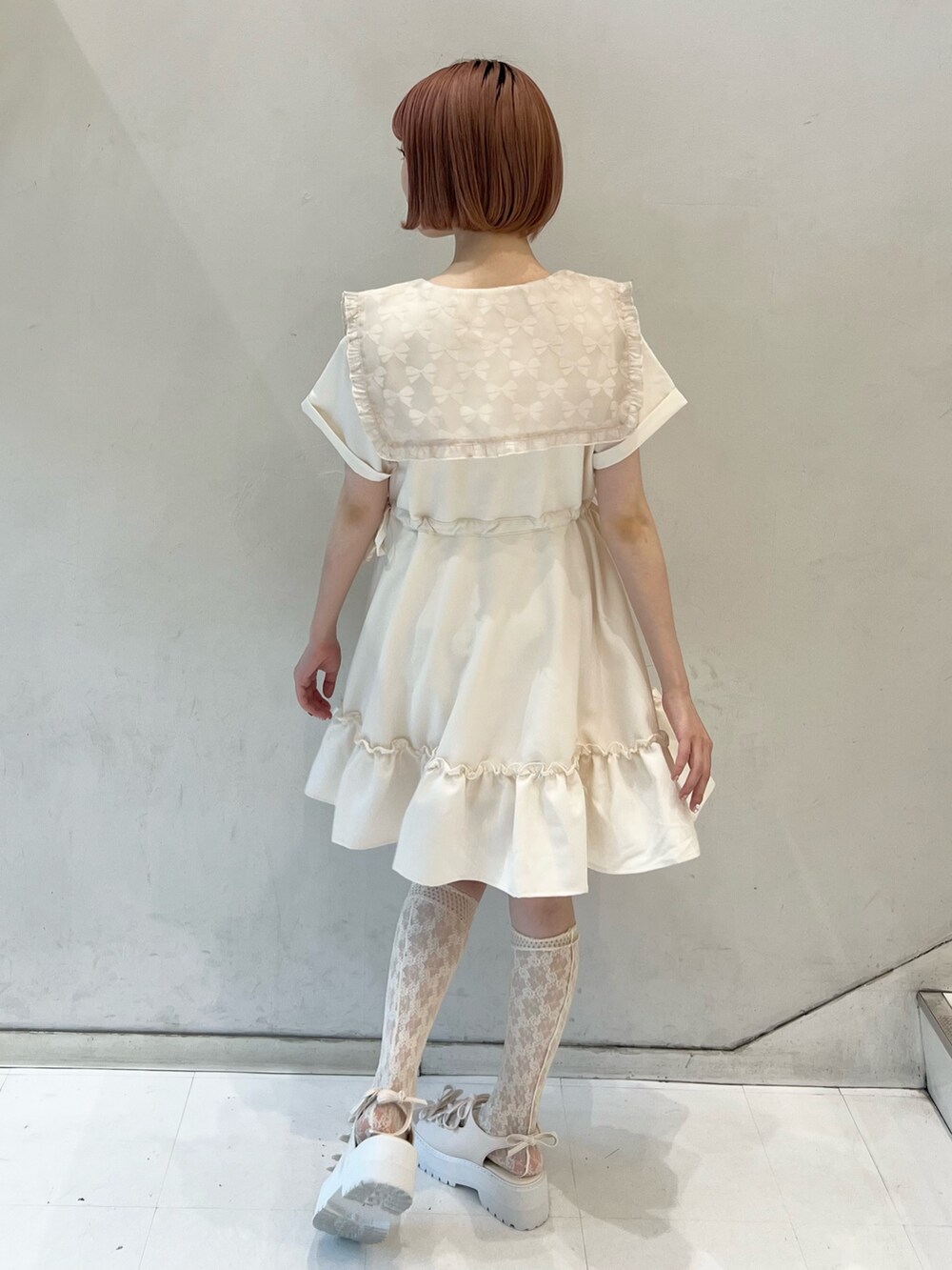 ピンク系のワンピース、ホワイト系のショルダーバッグ、ホワイト系のサンダルを着用したレディースの夏コーディネートの5枚目の写真