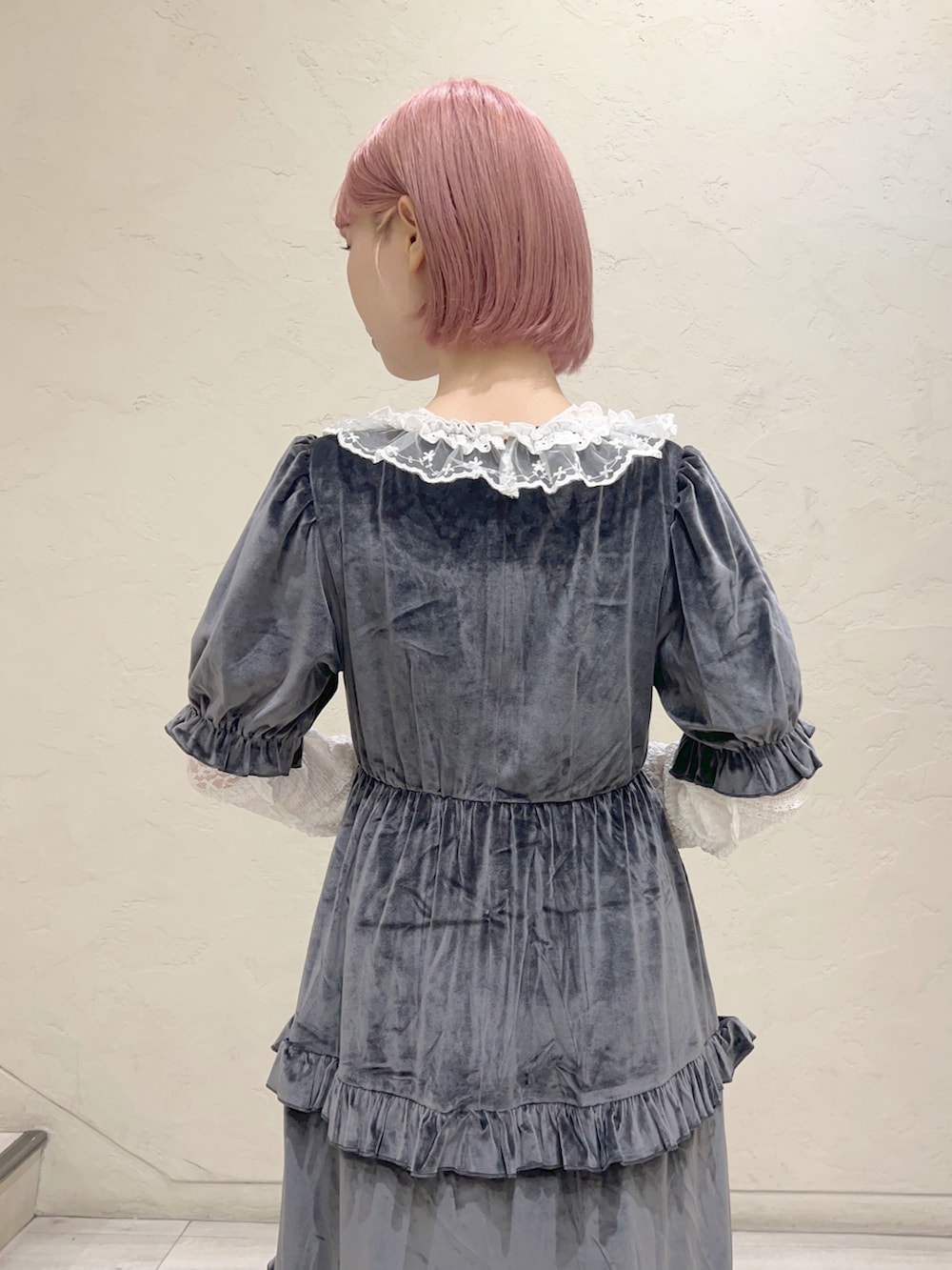 グレー系のワンピース、ブラウン系のハンドバッグ、ホワイト系のスニーカーを着用したレディースの夏コーディネートの7枚目の写真