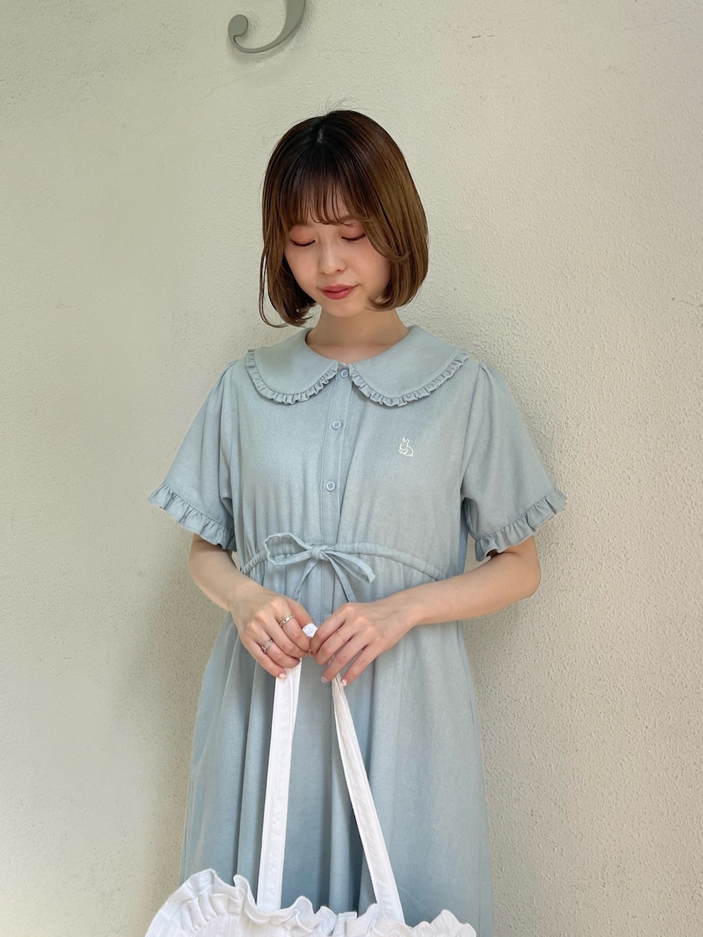 ブルー系のワンピース、ホワイト系のトートバッグ、ホワイト系のサンダルを着用したレディースの春コーディネートの2枚目の写真