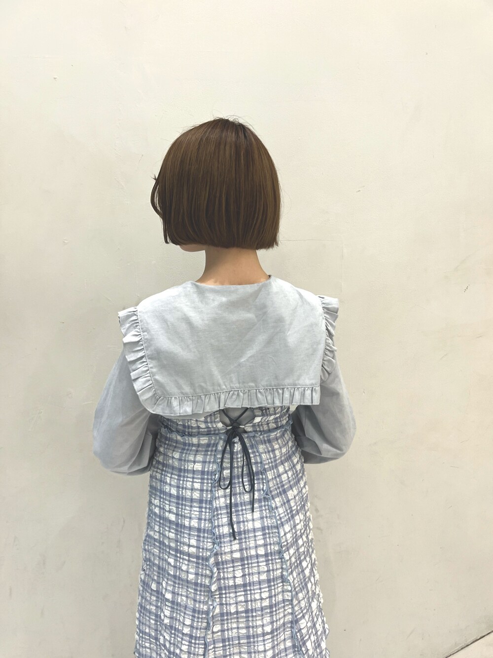 ブルー系のワンピース、ブルー系のシャツ/ブラウス、ホワイト系のパンプスを着用したレディースの春コーディネートの5枚目の写真