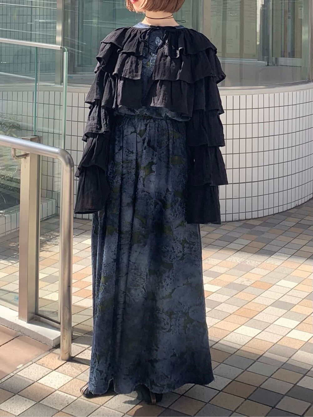 ブラック系のカーディガン/ボレロ、ブラック系のパンプス、ブルー系のワンピースを着用したレディースの冬コーディネートの2枚目の写真