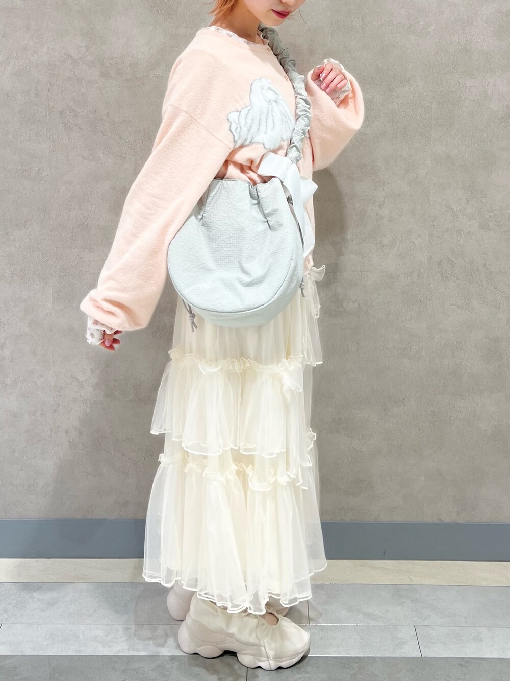 ピンク系のTシャツ/カットソー、ホワイト系のスカート、ホワイト系のスニーカーを着用したレディースの秋コーディネートの5枚目の写真